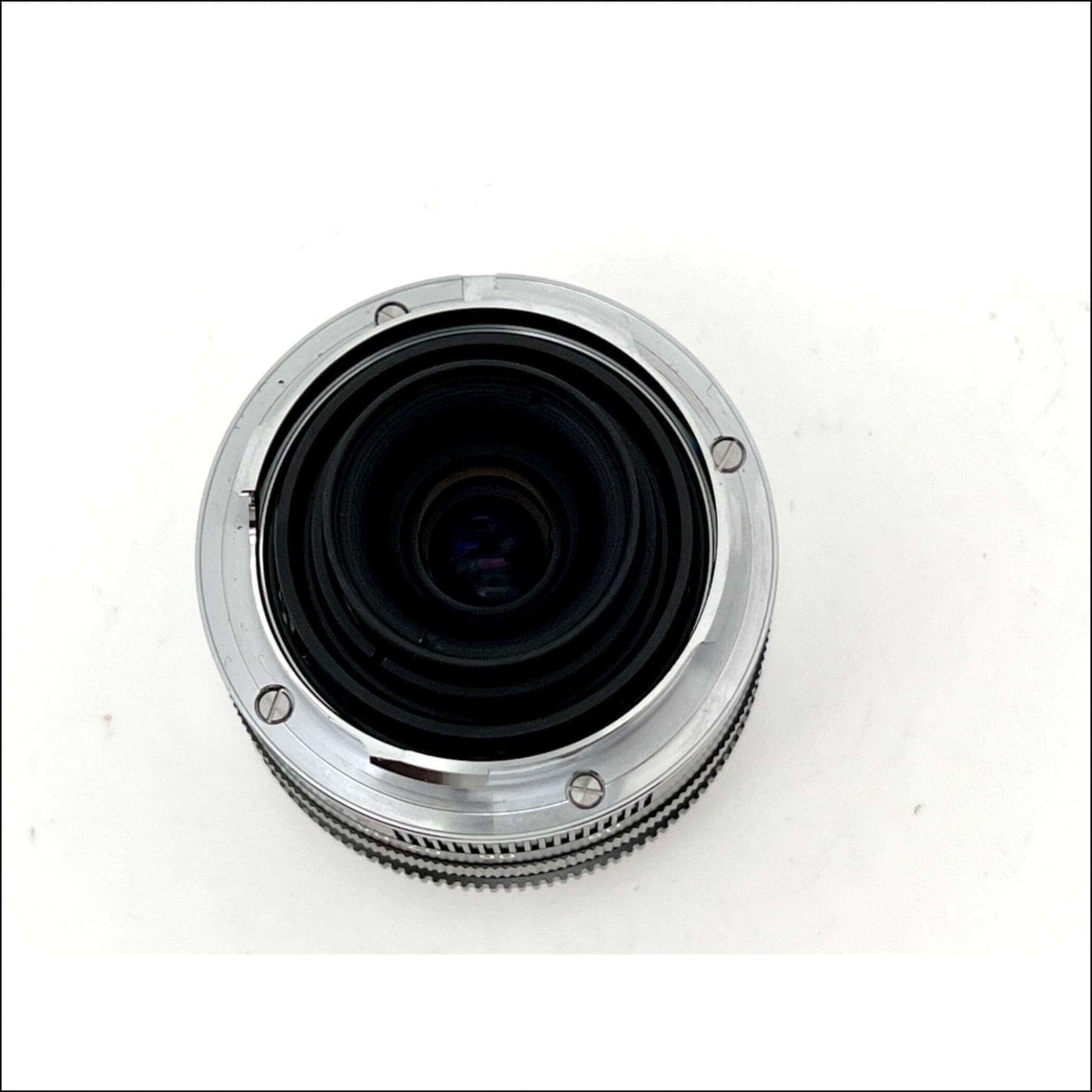 Top view of a vintage Carl Zeiss Biogon 28mm f2.8 T* lens showcasing its clean glass and metal body.