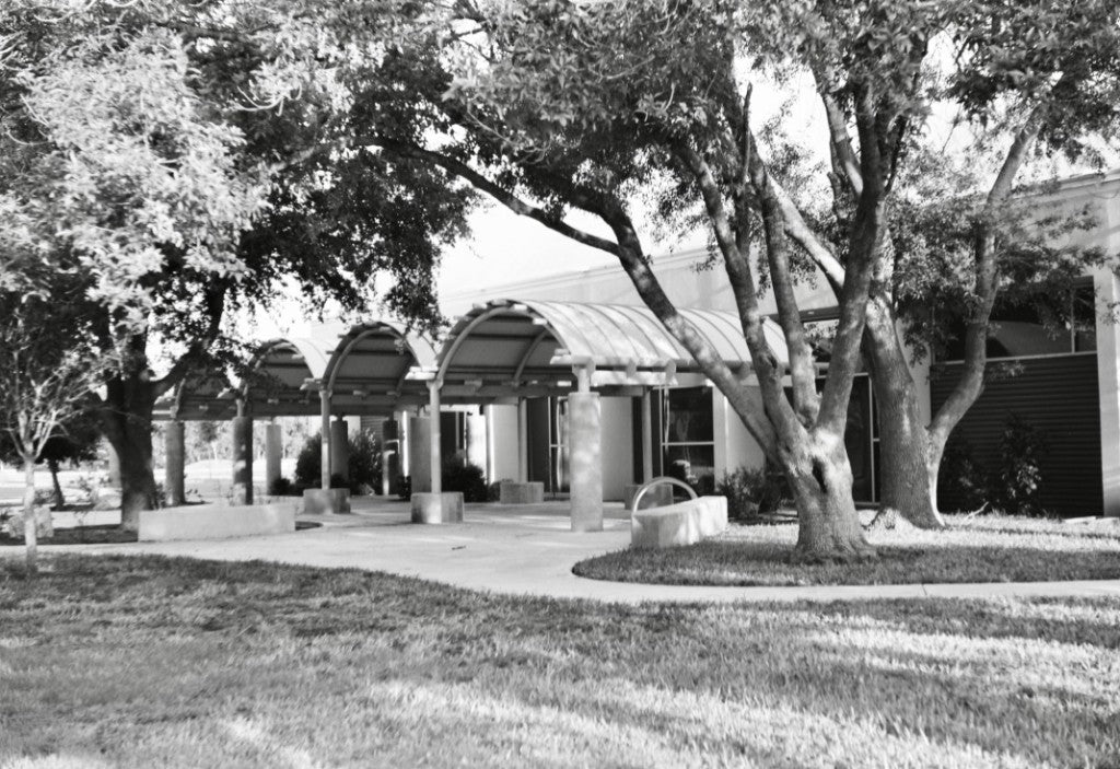 Arched colonnade and covered walk under trees at Jose "Pepe" Salinas Memorial Recreation Center, Elsa, shot on Arista 200 ISO Black & White 120 film, developed in standard black-and-white chemistry