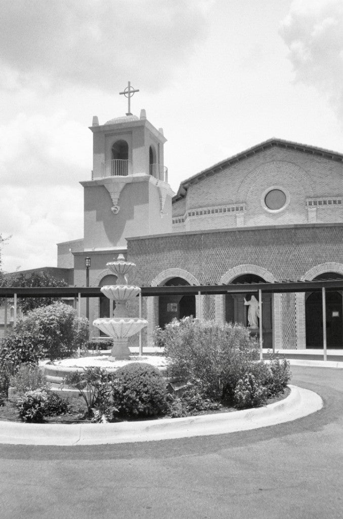 Courtyard fountain and terracotta bell tower at Sacred Heart Catholic Church, 501 E. Kuhn, Edinburg, Texas, shot on Kentmere 100 35mm film, developed in standard black-and-white chemistry