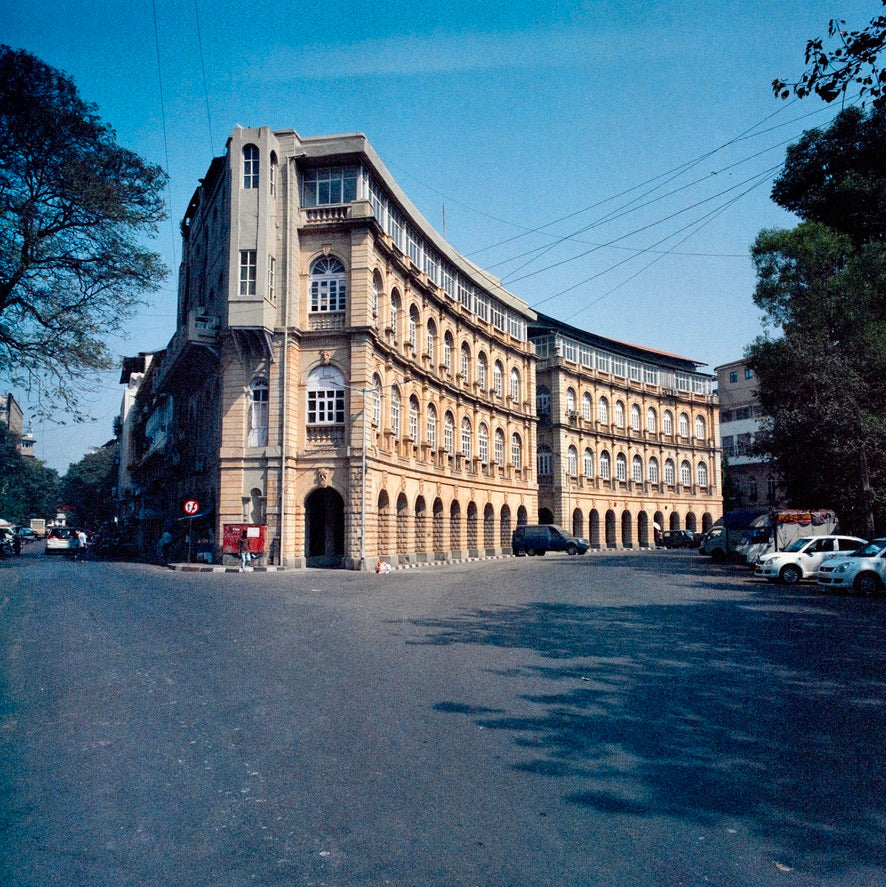 Hasselblad SWCM / 120 + Kodak Vision3 500T + Mumbai curved arcade historic stone building at a wide street intersection