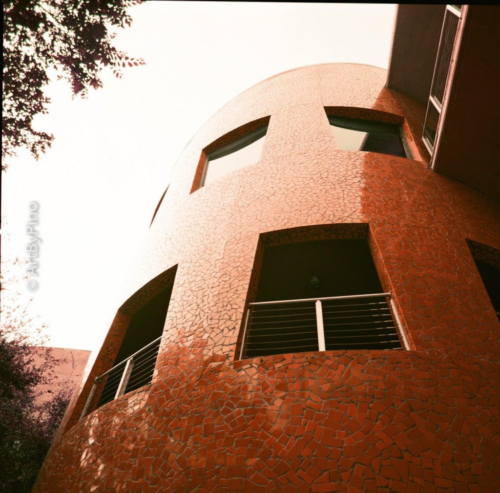Curved orange mosaic-tiled building low angle — Hasselblad 500CM + LomoChrome Purple 400 + 120