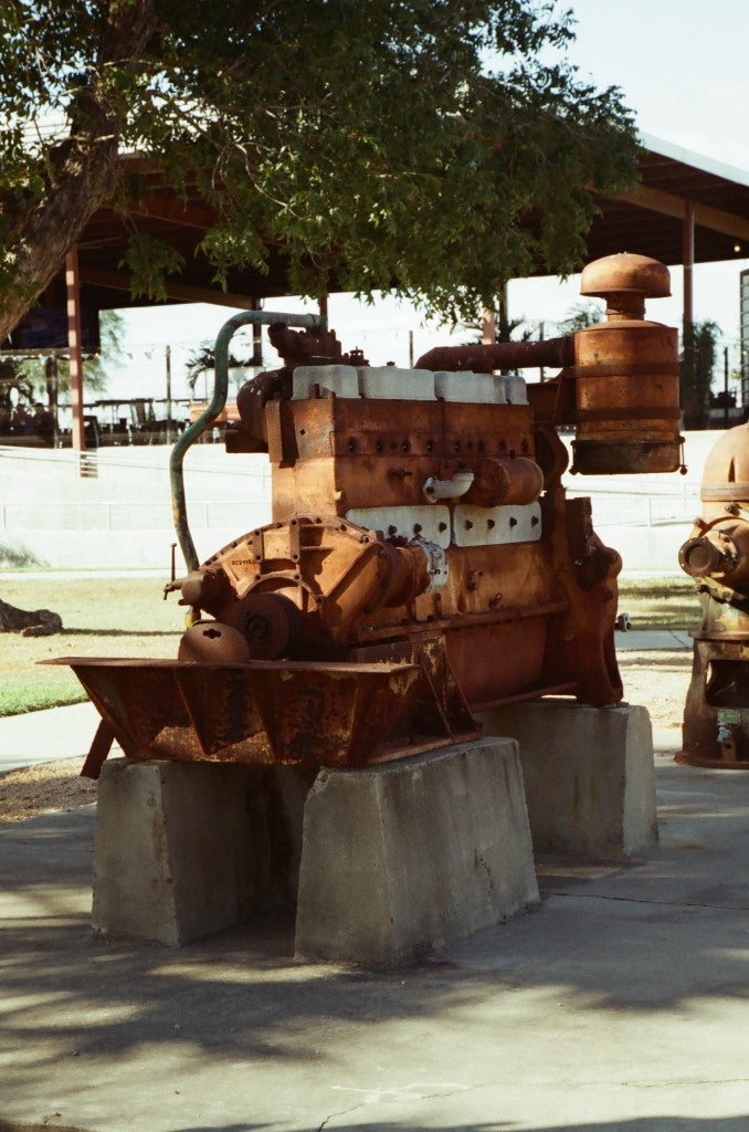 35mm + Reflx Lab 320D AHU — Rusted historic engine on concrete blocks at the McAllen Pumphouse and Firemen’s Park, McAllen, Texas