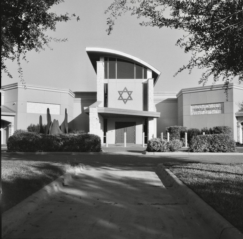 Templo Emanuel McAllen desde la acera, árboles enmarcando la fachada de la Estrella de David, fotografiada con película Rollei RPX 100 120, revelada con química estándar en blanco y negro.