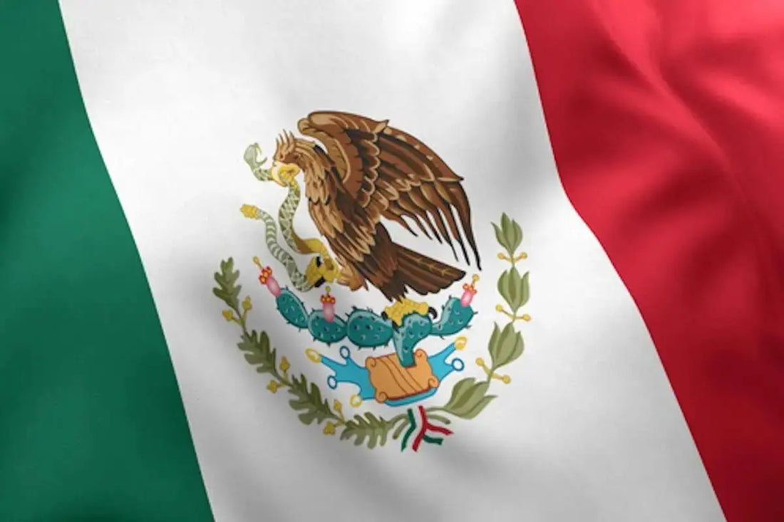 The mexican flag, featuring vertical stripes of green, white, and red with a central emblem depicting an eagle perched on a cactus holding a serpent.