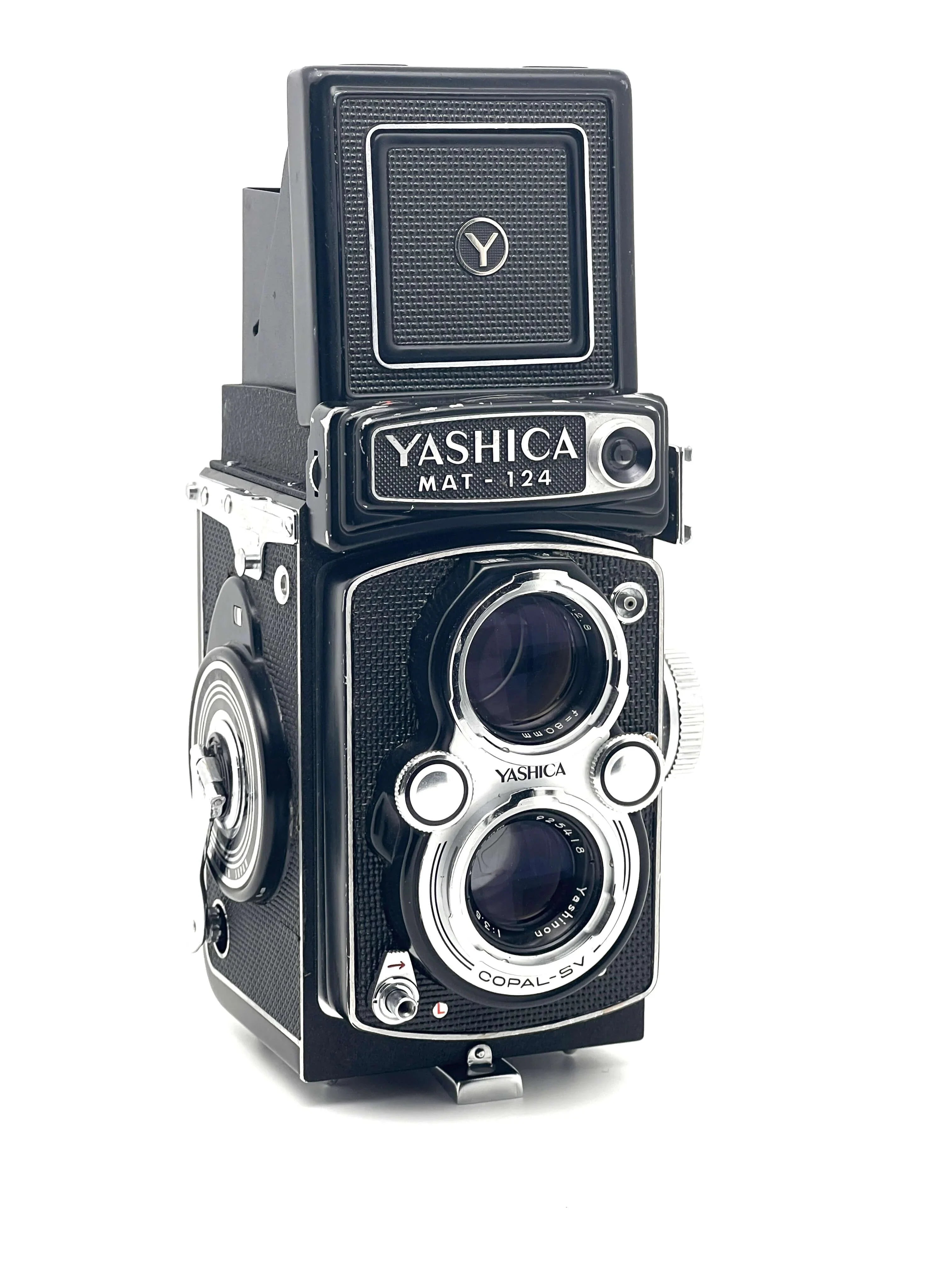 Black and silver yashica mat-124 twin-lens reflex camera with textured body and chrome accents.