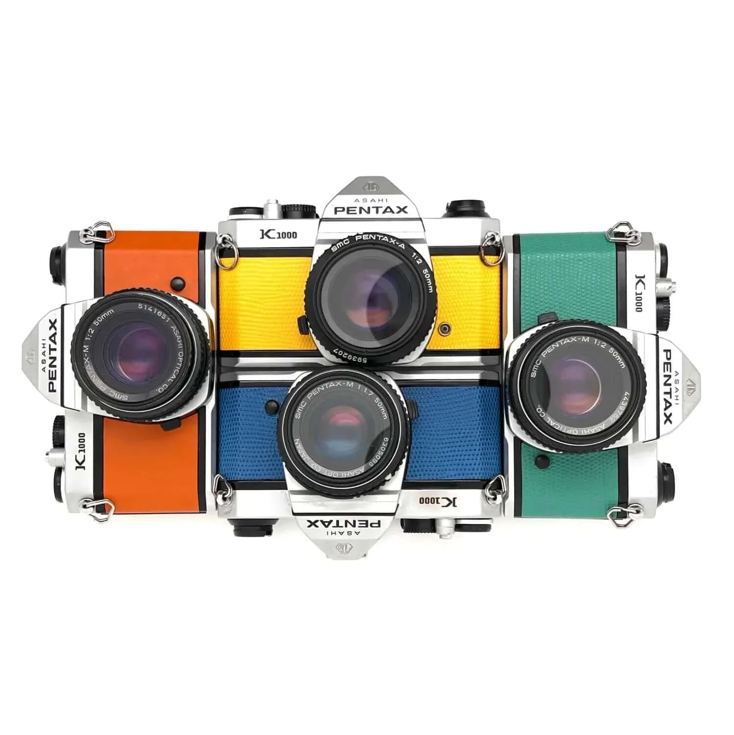 Four vintage pentax k1000 film cameras, each with a distinct colored leather strap—orange, yellow, blue, and green—and silver metal bodies.