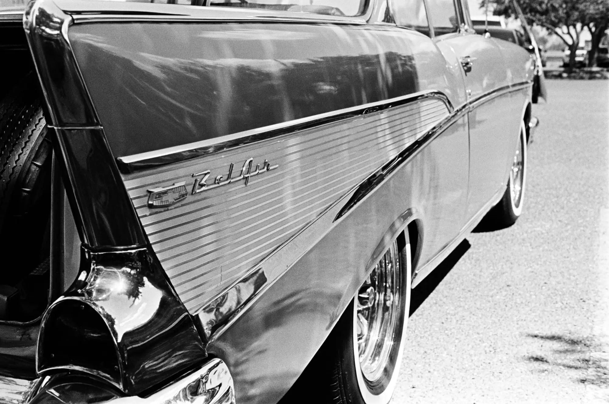 Shiny black 1957 chevrolet bel air with chrome trim and distinctive tailfins.