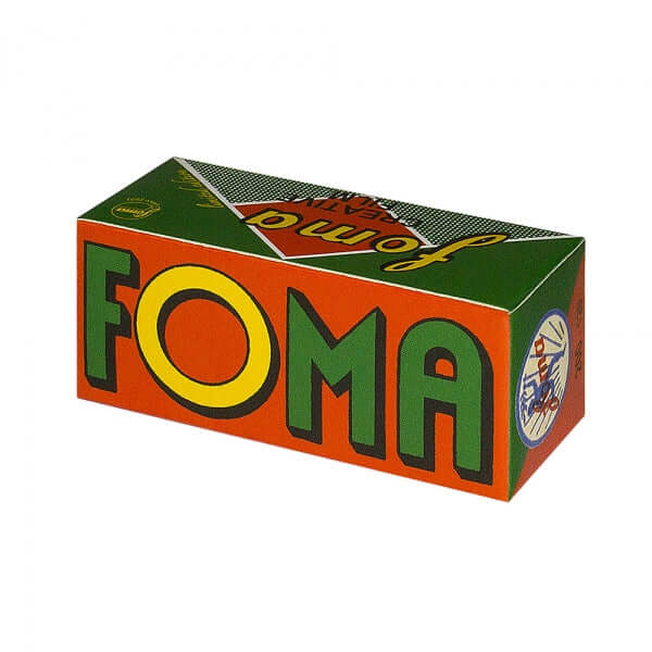 Vibrant orange and green cardboard box with bold yellow-green ’foma’ lettering, featuring a retro design and circular logo on the side.