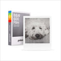 White polaroid b&w 600 film pack with a rainbow-colored spine and an instant photo of a fluffy dog.