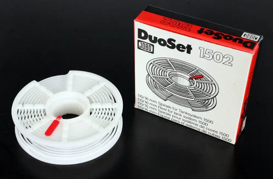 Jobo DuoSet 1502 film spirals for developing 110 and 16mm film, shown with packaging on a black background