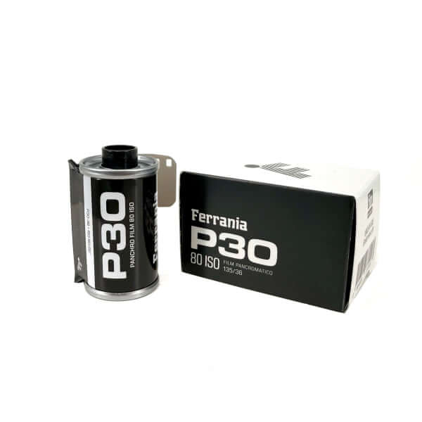 Black ferrania p30 80 iso film canister with silver metallic edges and white text, displayed beside its matching black packaging.