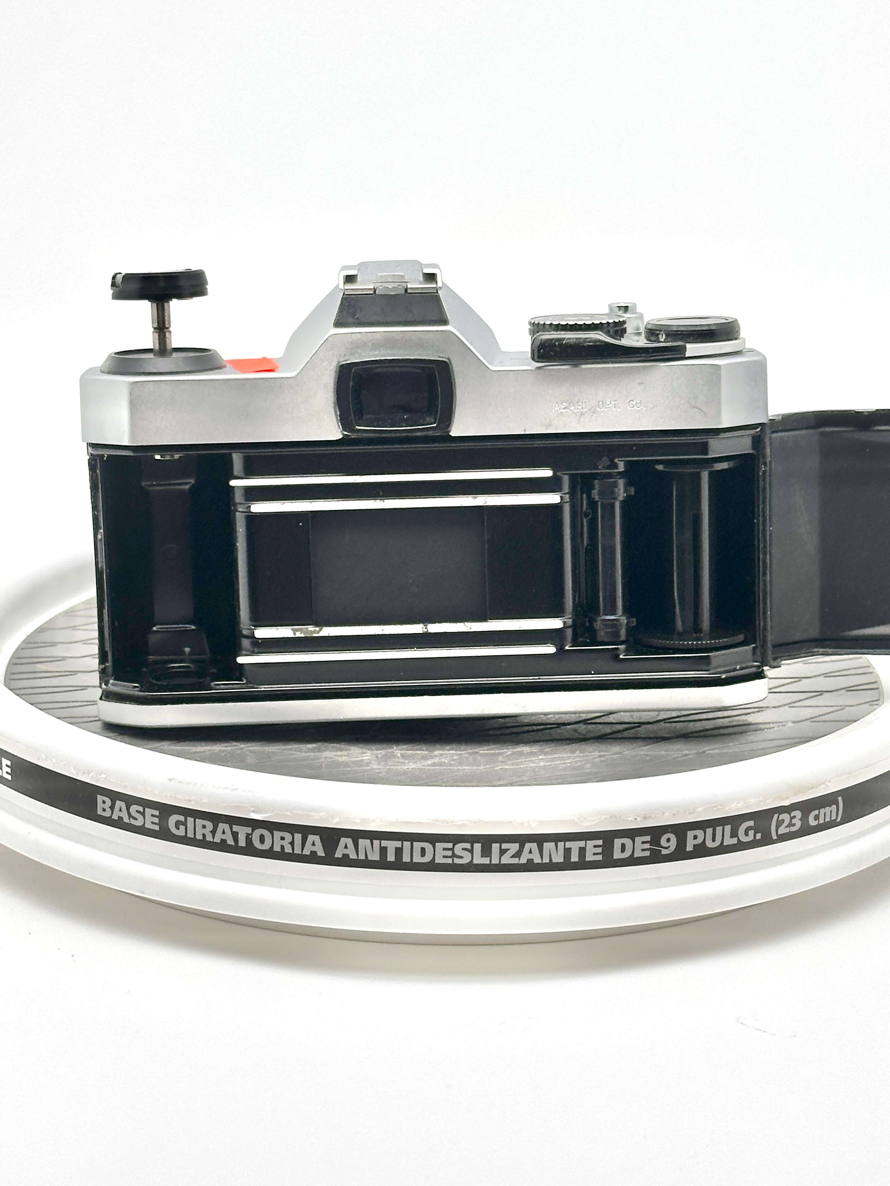 Silver and black vintage film camera with a metallic body, exposed shutter mechanism, and visible lens mount.
