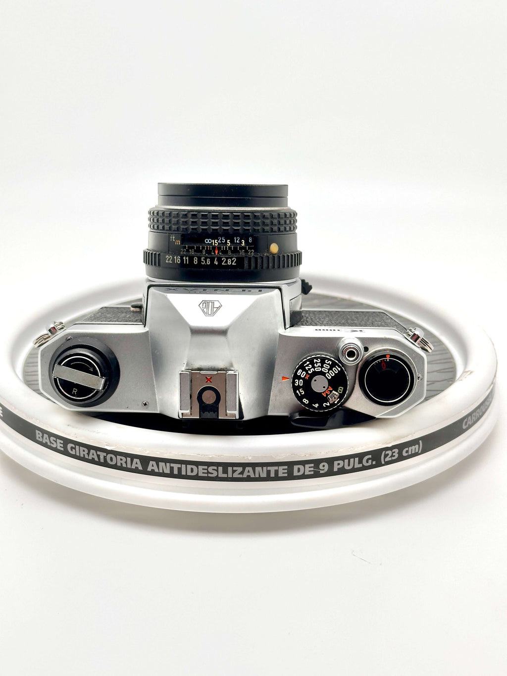 Silver-bodied canon ae-1 film camera with a black lens and textured dials.