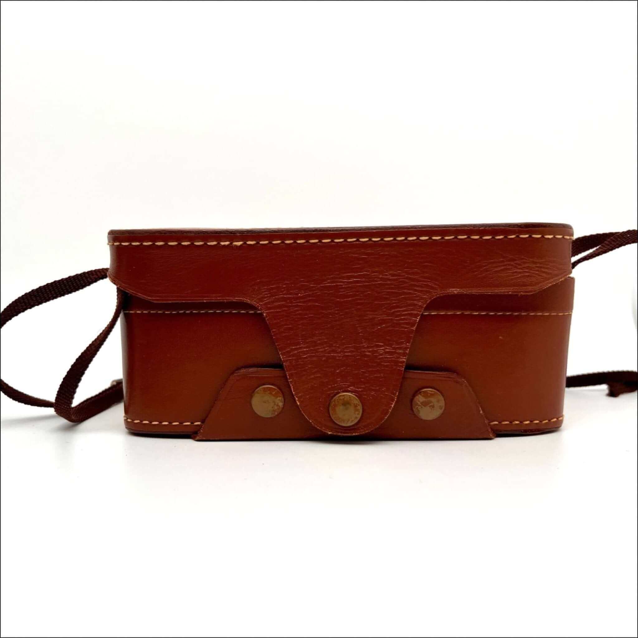 Brown leather camera case with tan stitching and brass-toned metal fasteners.