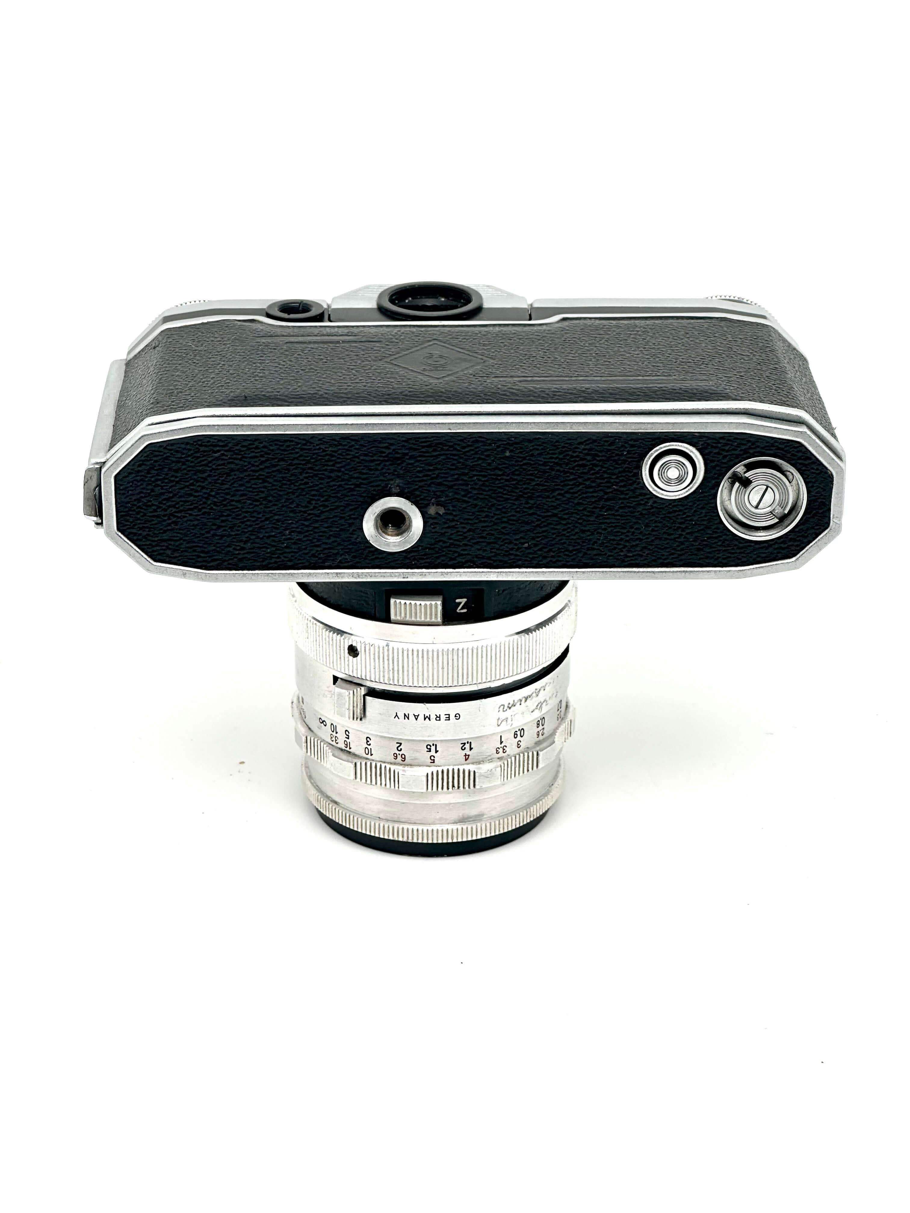 Silver and black leica camera body with a matching silver lens mounted on top.