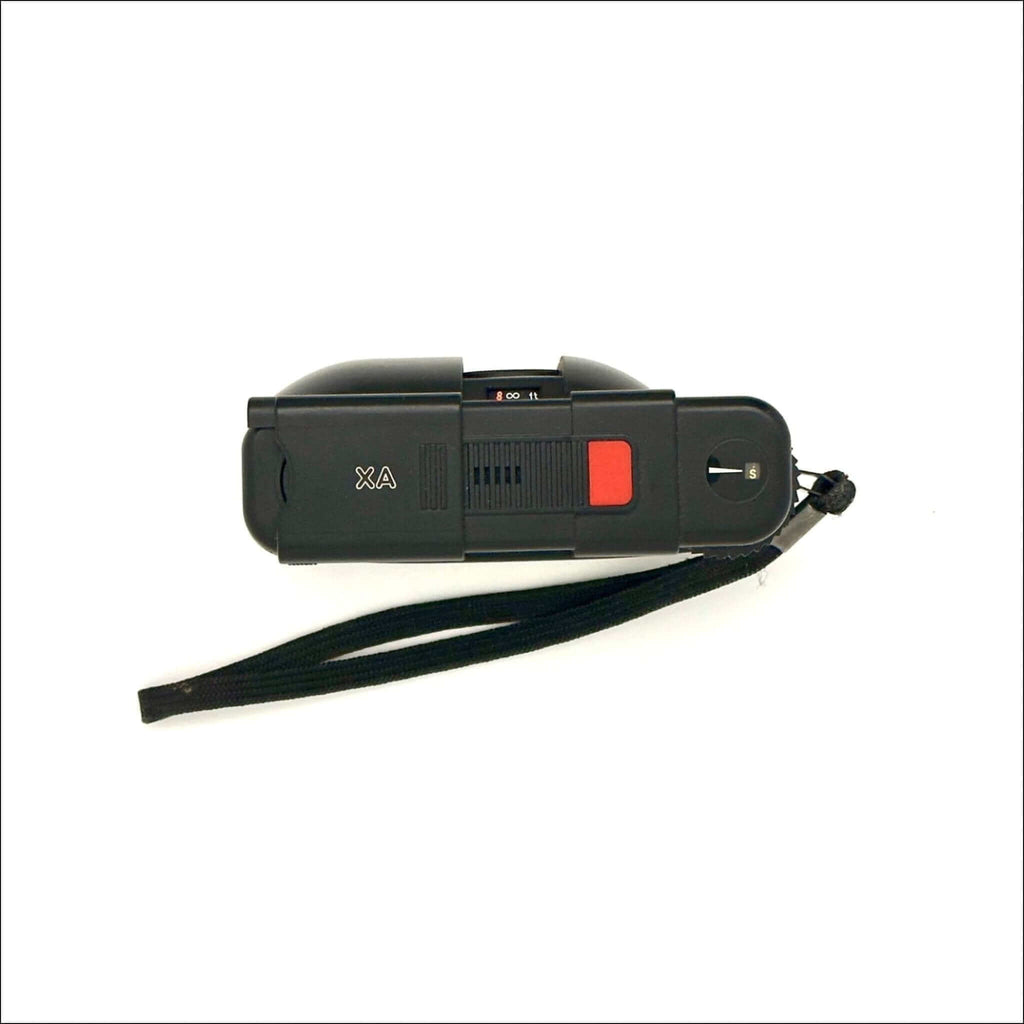 Black plastic stun gun with a red trigger and a black wrist strap.