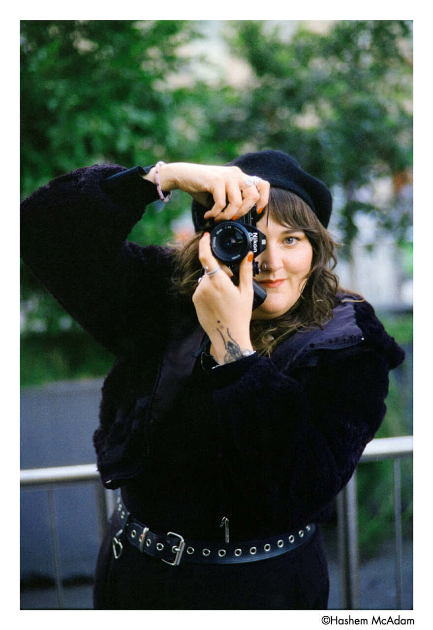 Black nikon camera with a lens cap on the front