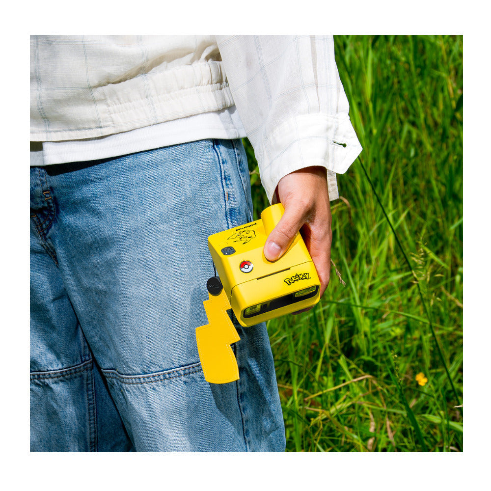 Polaroid Go Gen 3 Pikachu Edition carried by its lightning-bolt lanyard charm
