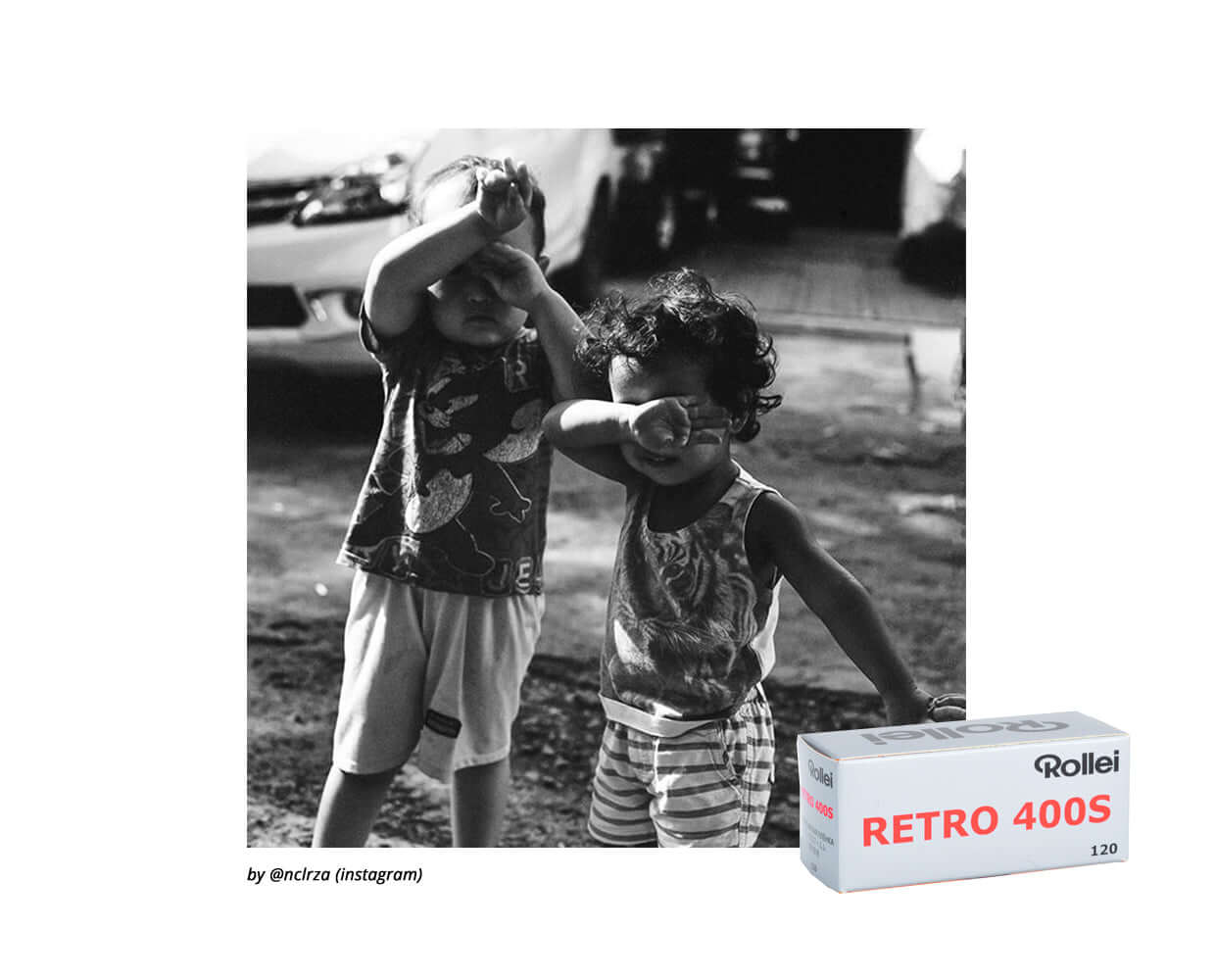 Black and white photo of two children playing outdoors next to a box of Rollei Retro 400S black and white 120 film.