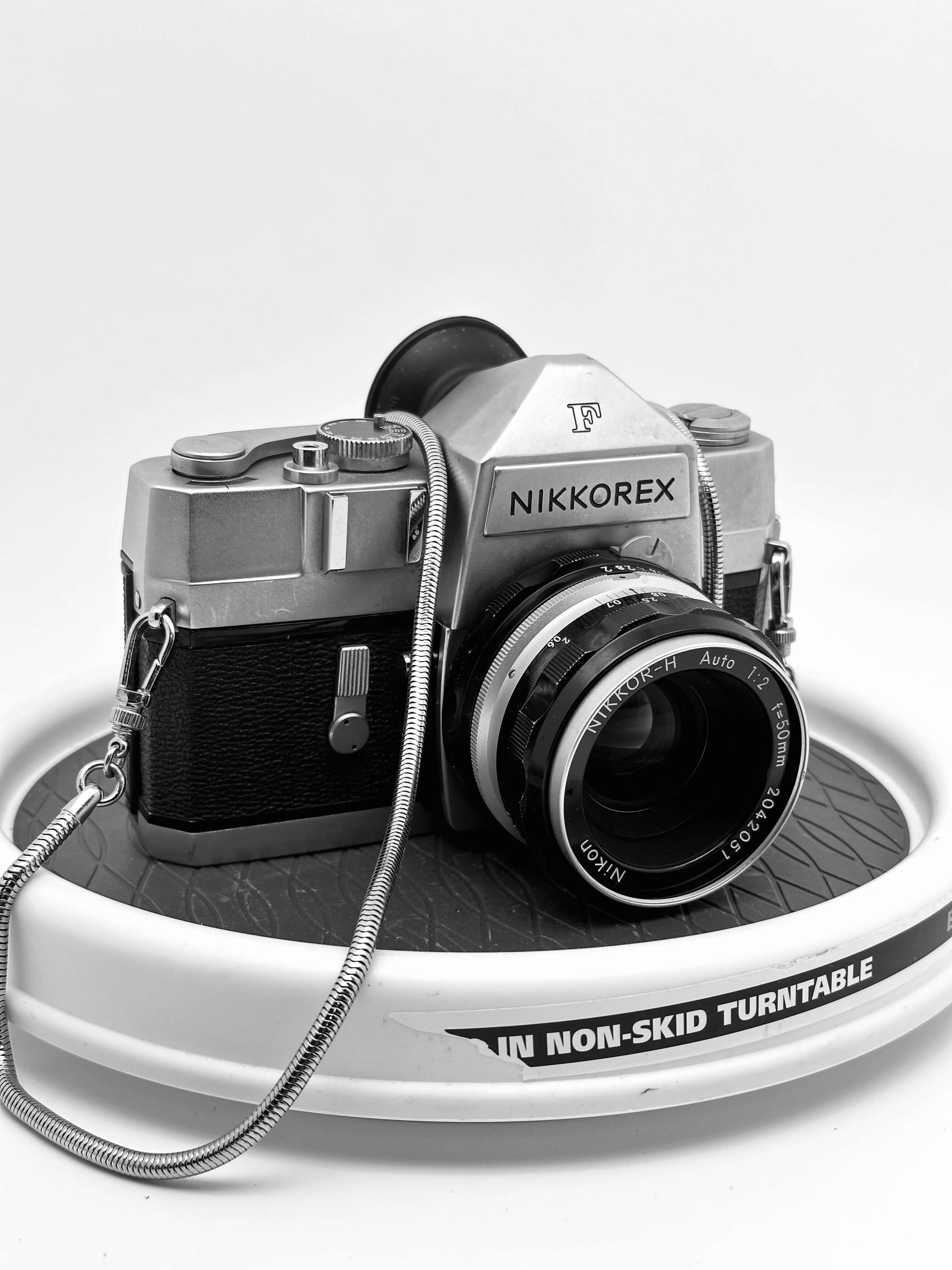 Nikkorex F 35mm film camera with 35mm f/2.8 lens displayed on a non-skid turntable, showcasing its vintage design.