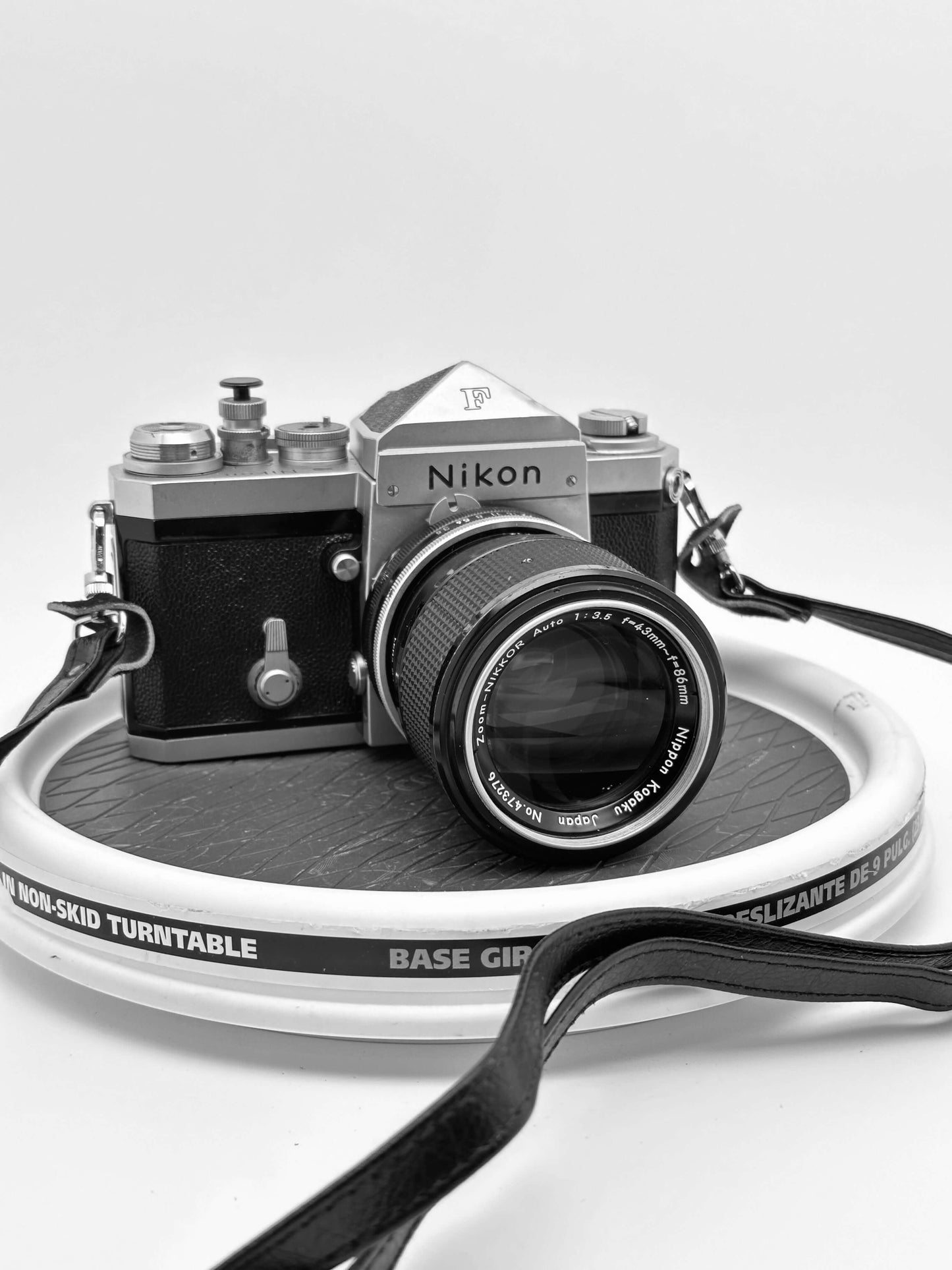 Vintage Nikon F 35mm film camera with Nikkor 43-86mm f/3.5 zoom lens in used condition on display.