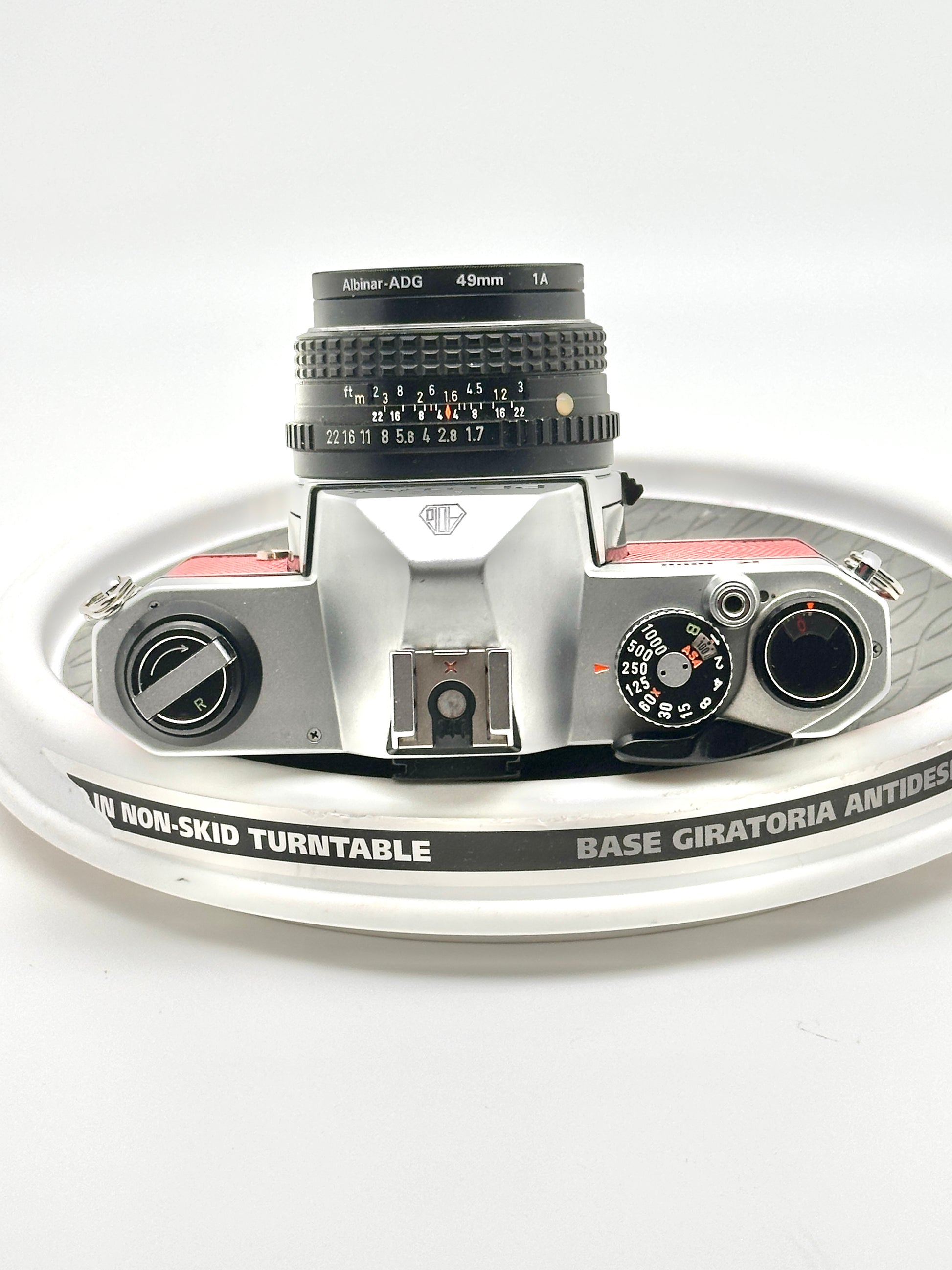 Japanese Asahi Pentax K1000 35mm film camera with 50mm f1.7 lens on a turntable, showcasing its classic design.