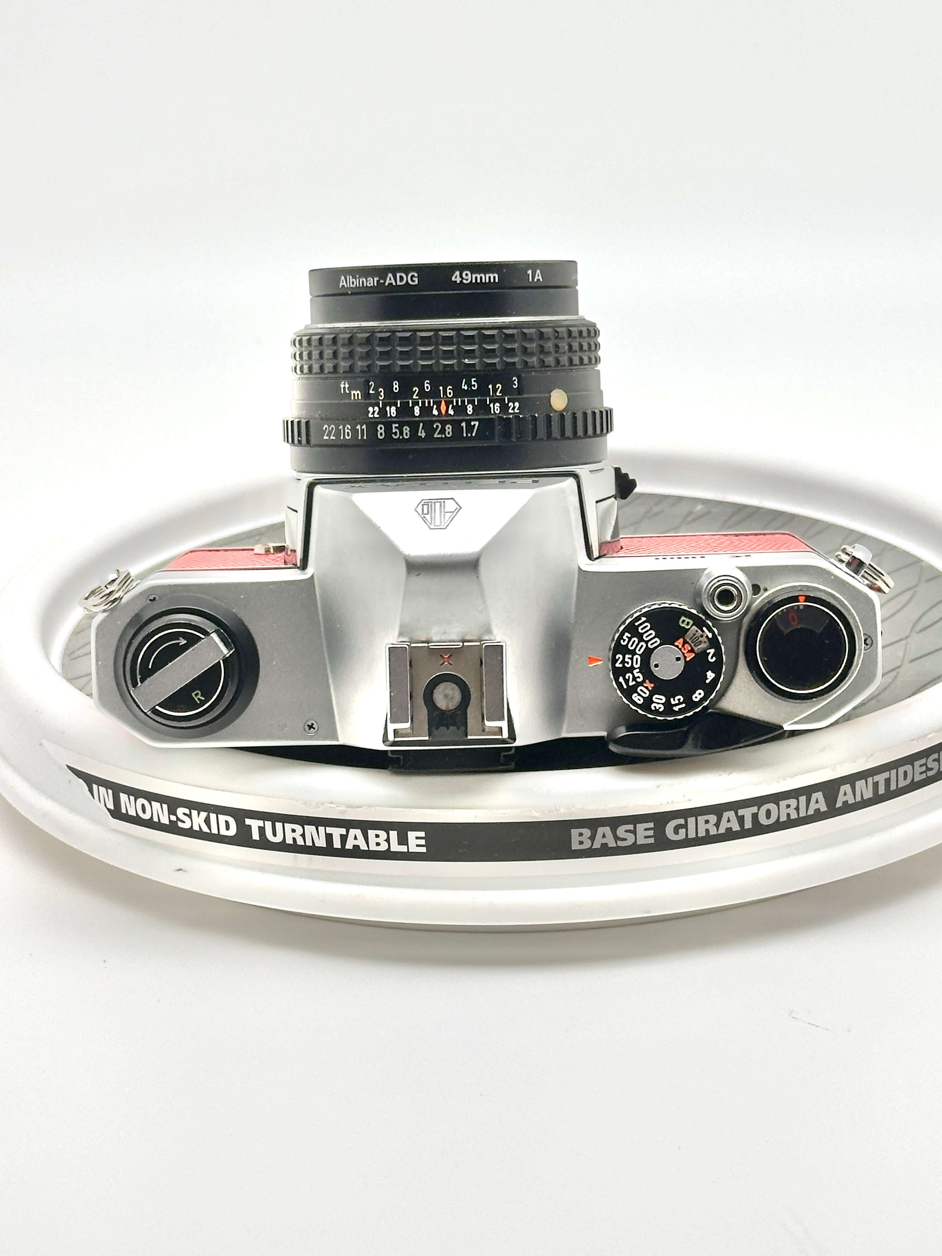 Vintage Japanese Asahi Pentax K1000 camera top view with 50mm f1.7 lens on non-skid turntable