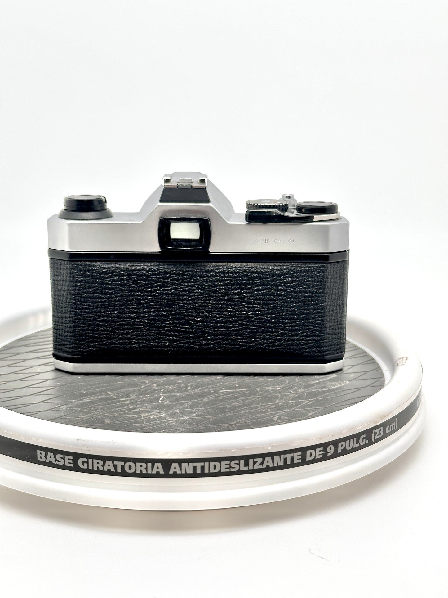 Rear view of a Japanese Asahi Pentax K1000 black 35mm film camera on a rotating display base.