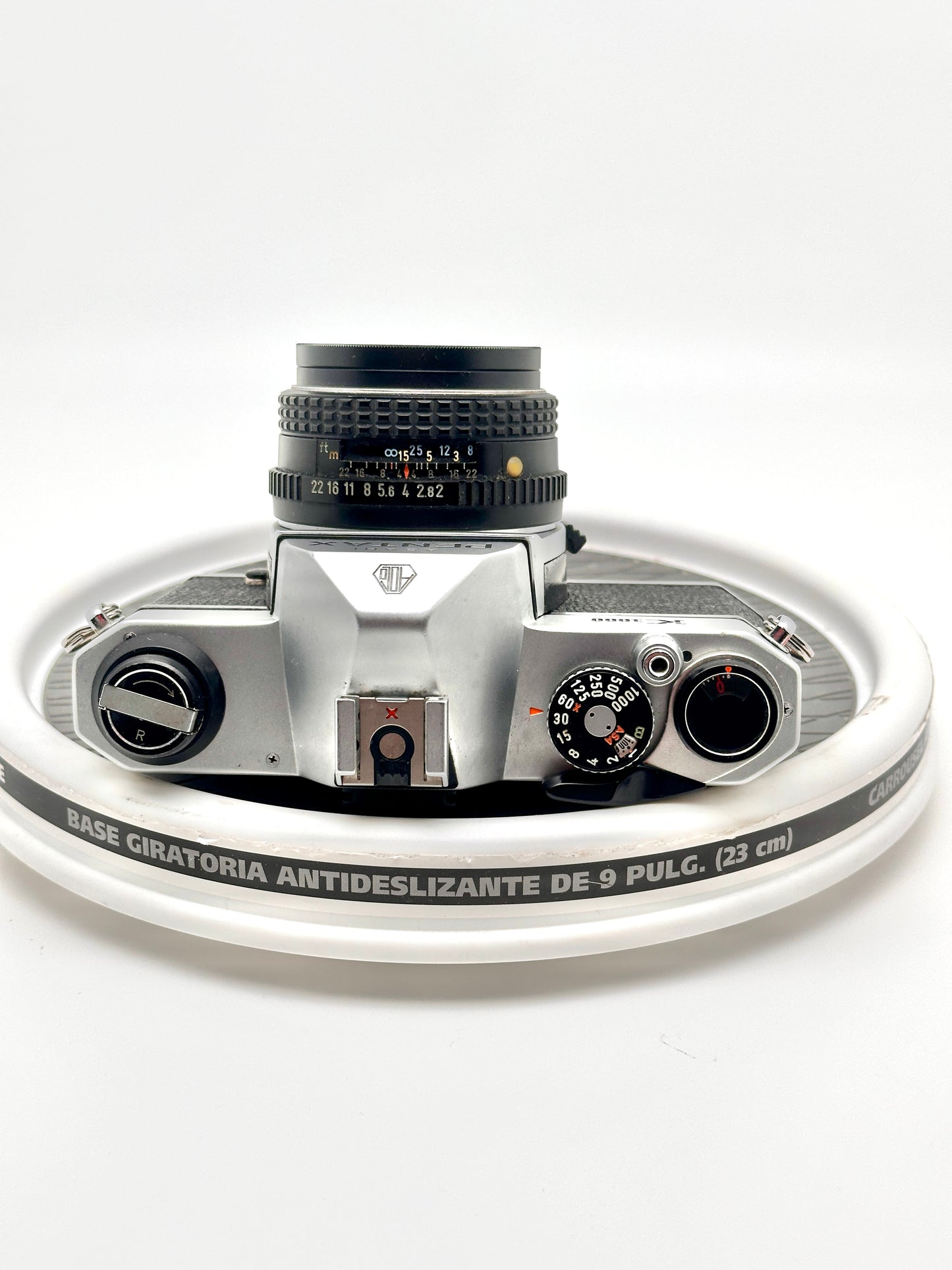 Close-up of a silver Pentax K1000 camera with a 50mm lens, highlighting its vintage design and controls.