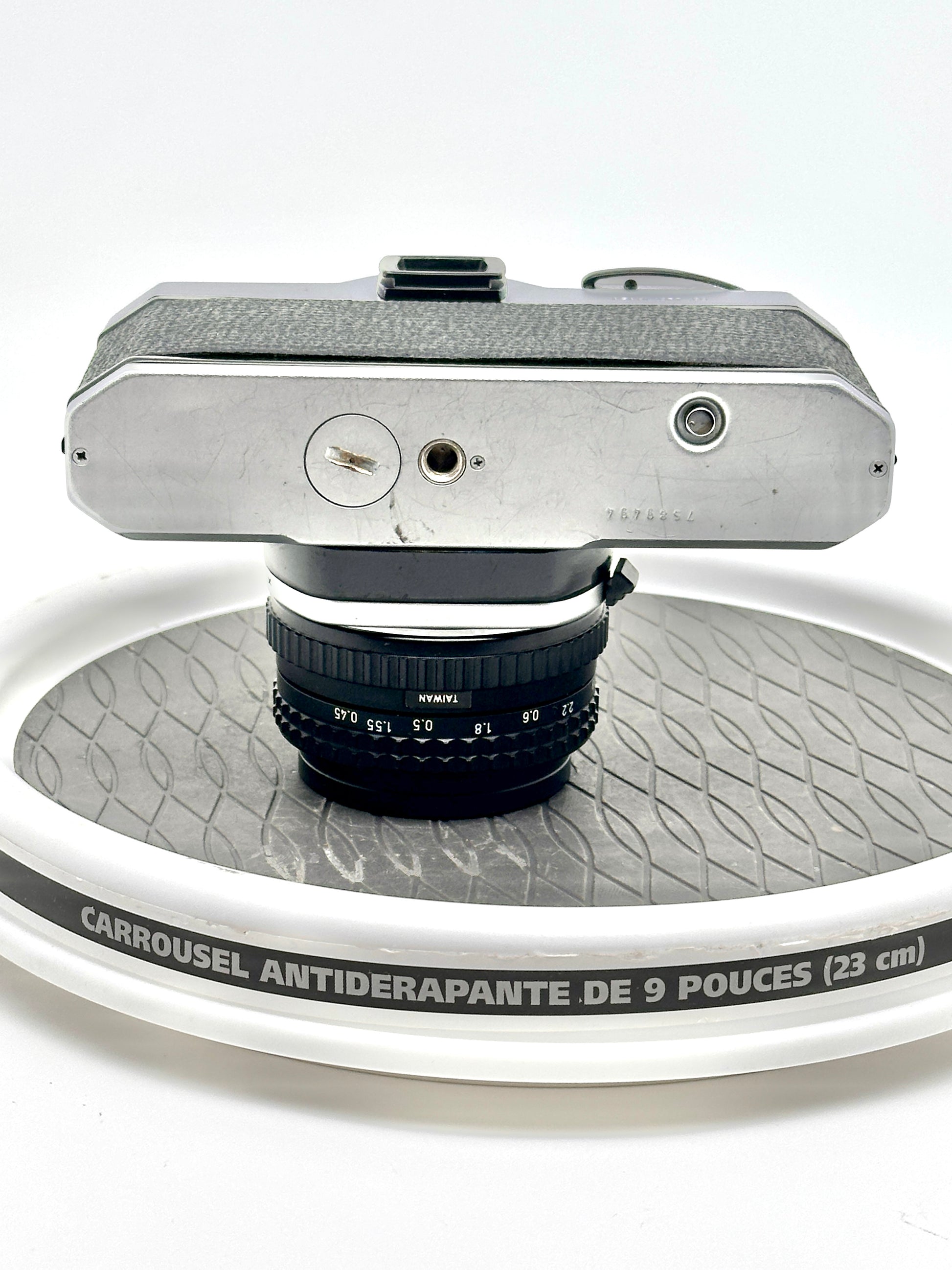 Japanese Asahi Pentax K1000 black 35mm film camera top view with 50mm lens on a non-slip display carousel.