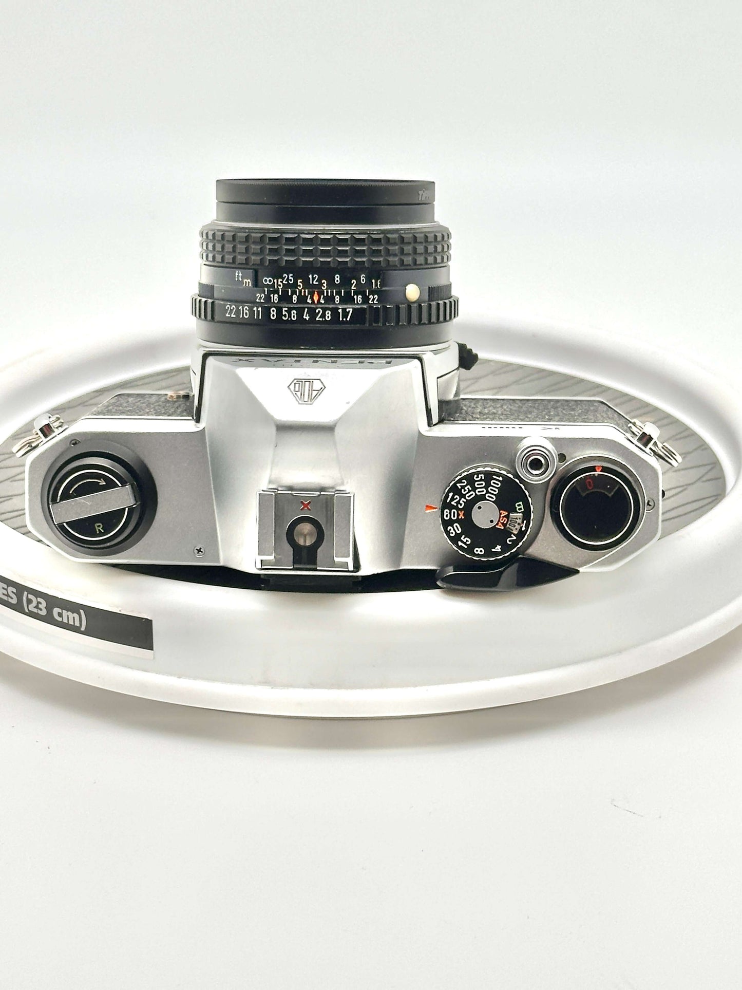 Japanese Asahi Pentax K1000 black 35mm film camera top view with 50mm f1.7 lens, showcasing classic design and controls.