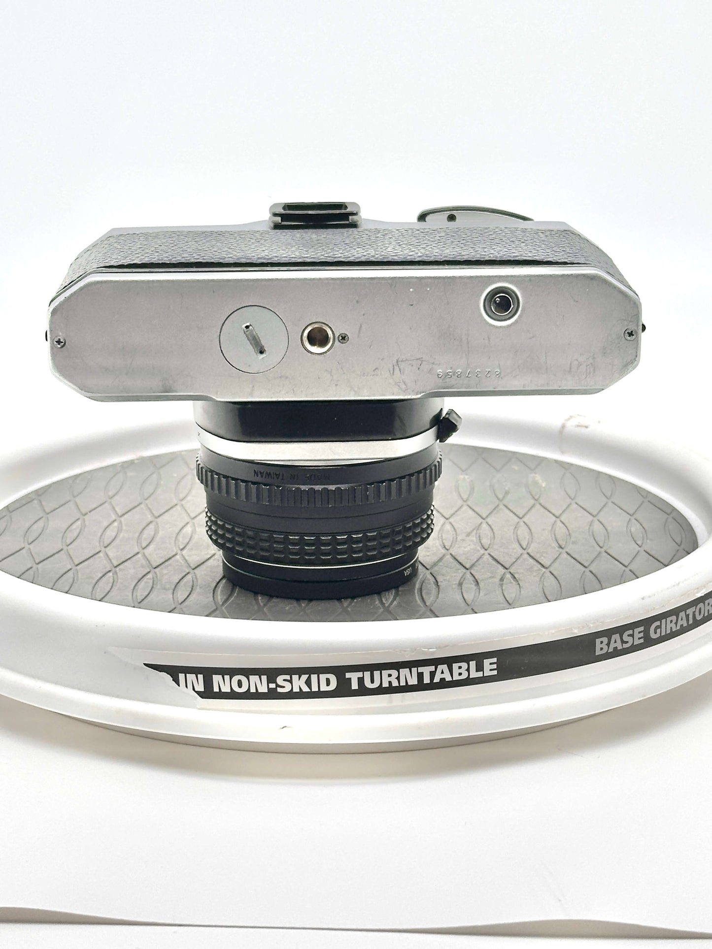 Top view of a Japanese Asahi Pentax K1000 35mm film camera on a non-skid turntable.