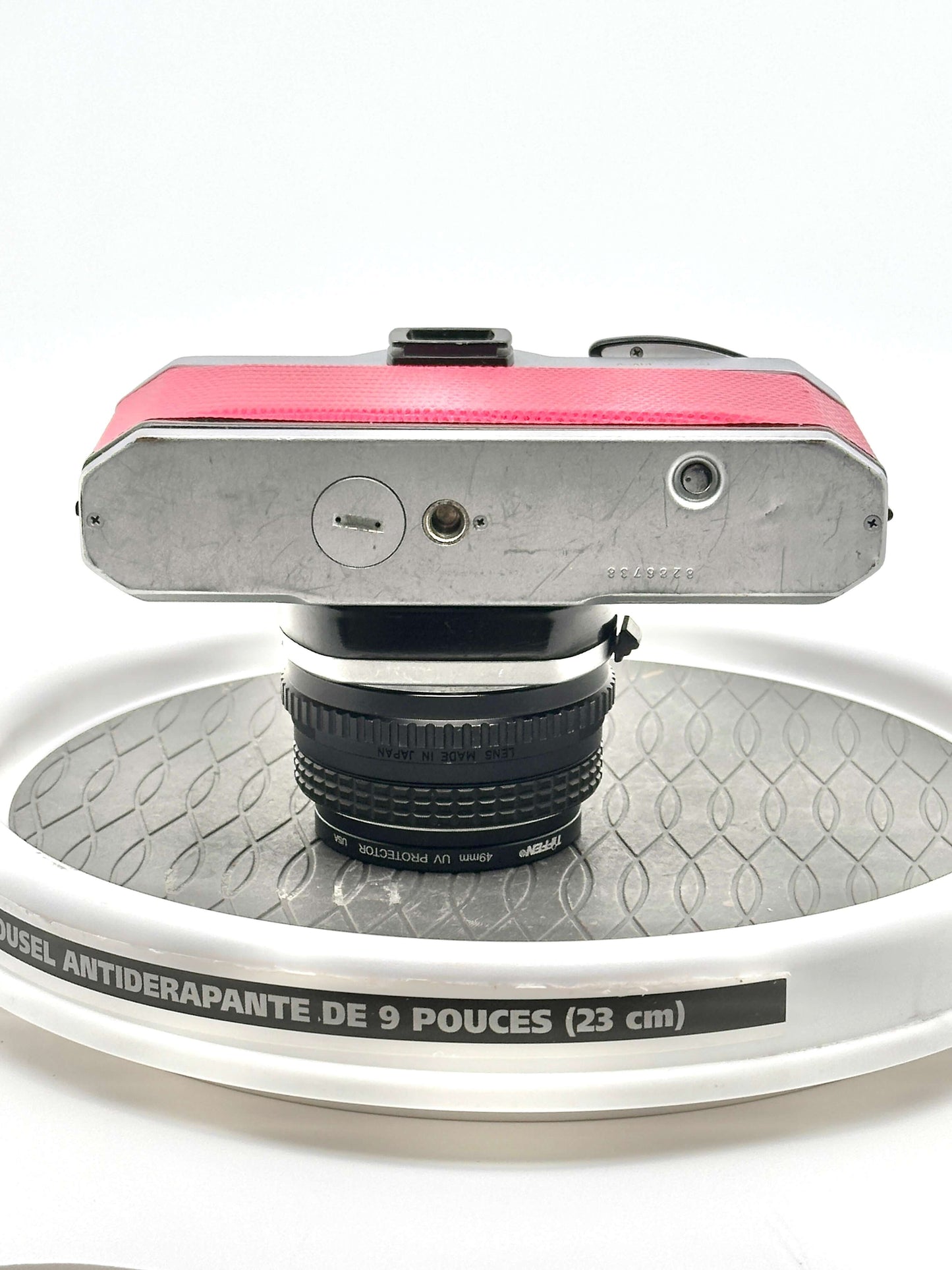 Japanese Asahi Pentax K1000 Red 35mm film camera showing top view with 50mm f1.7 lens on a display surface.