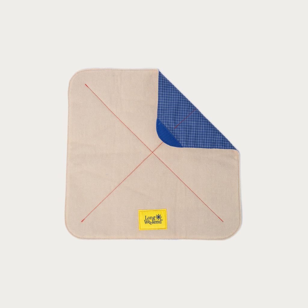 Long Weekend padded camera wrap with one corner folded back to show the blue grid ripstop lining