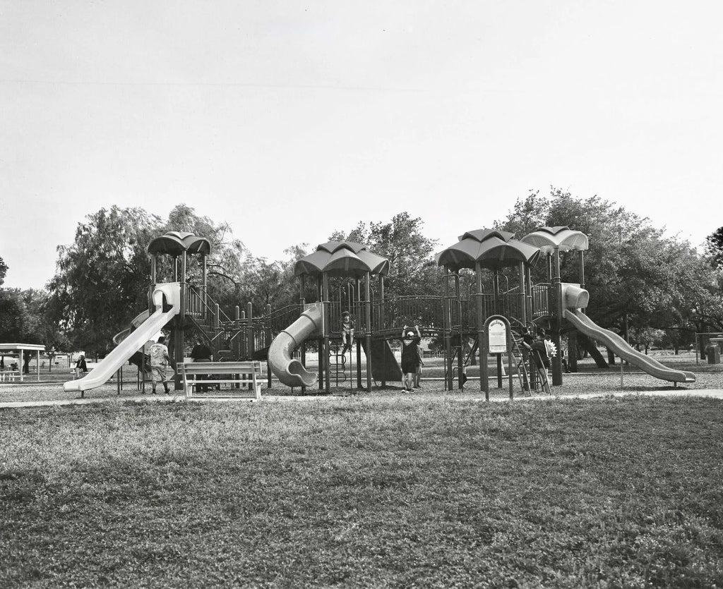 Black-and-white playground structure with multiple slides and climbing areas