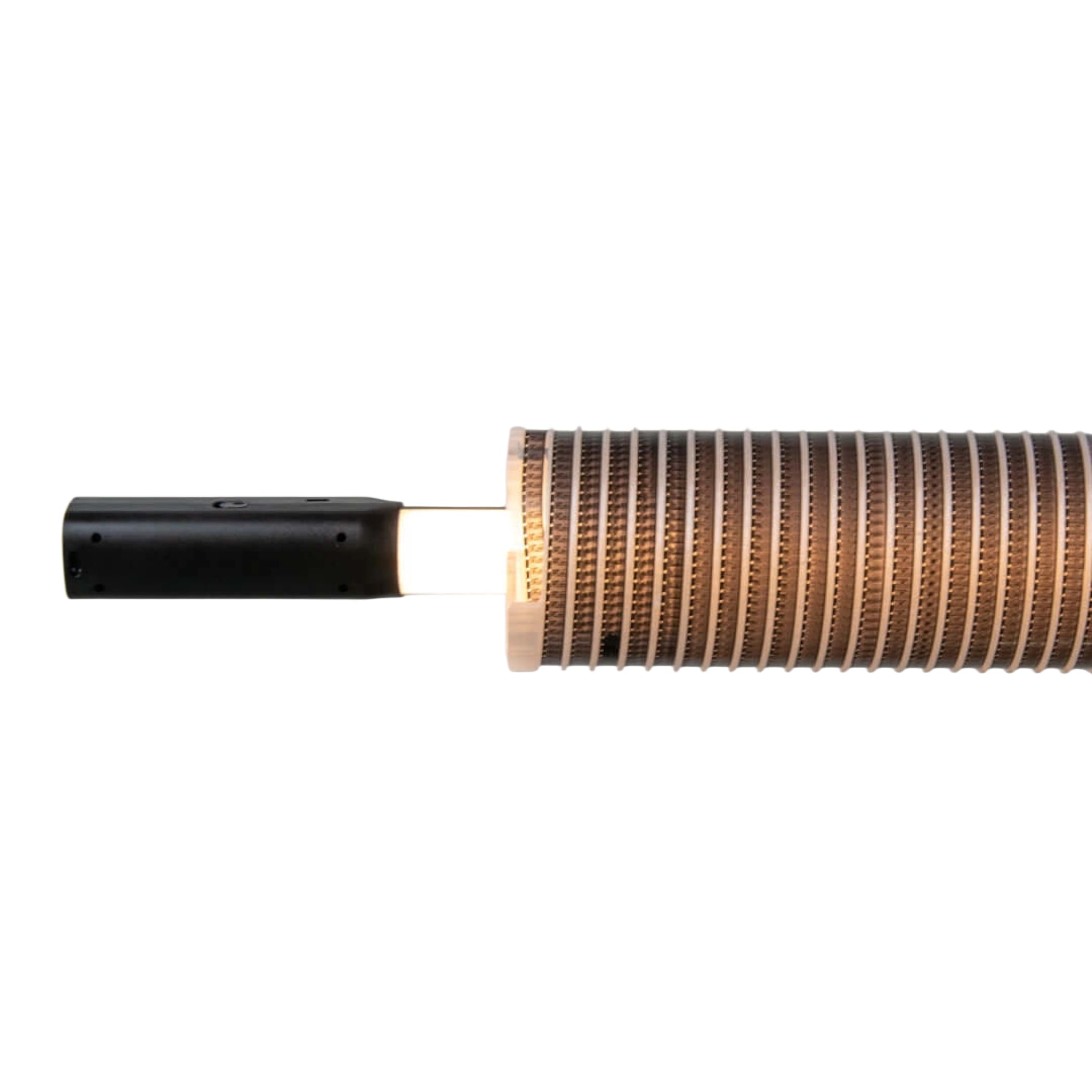 A sleek black cylindrical handle connects to a segmented, copper-toned heat exchanger with fine ridged grooves.