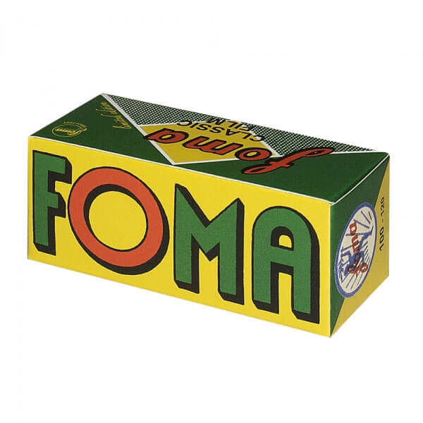 Vibrant yellow and green cardboard box with bold red-and-green ’foma’ lettering, featuring a retro design and classic branding.