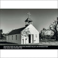 A small, white adobe church with a bell tower topped by a cross.