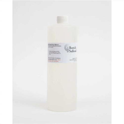 A translucent white plastic bottle with a white cap, labeled ’bostick sullivan’ and marked as containing 1000 ml of bsi rapid fixer solution.