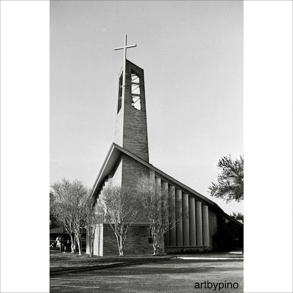 Modern brick church with a tall, angular bell tower topped by a cross.