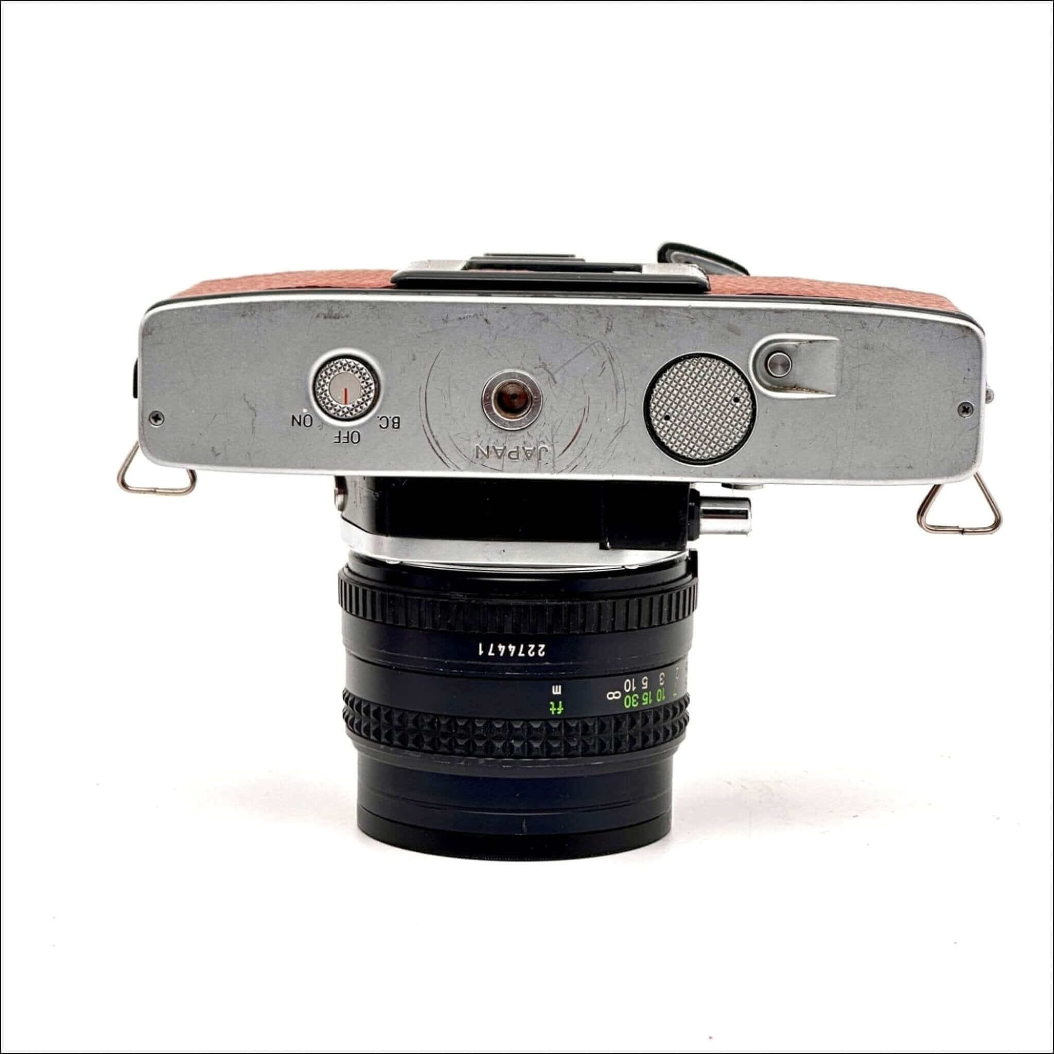 Silver-bodied vintage camera with a brown leather top and a black lens mounted on it.