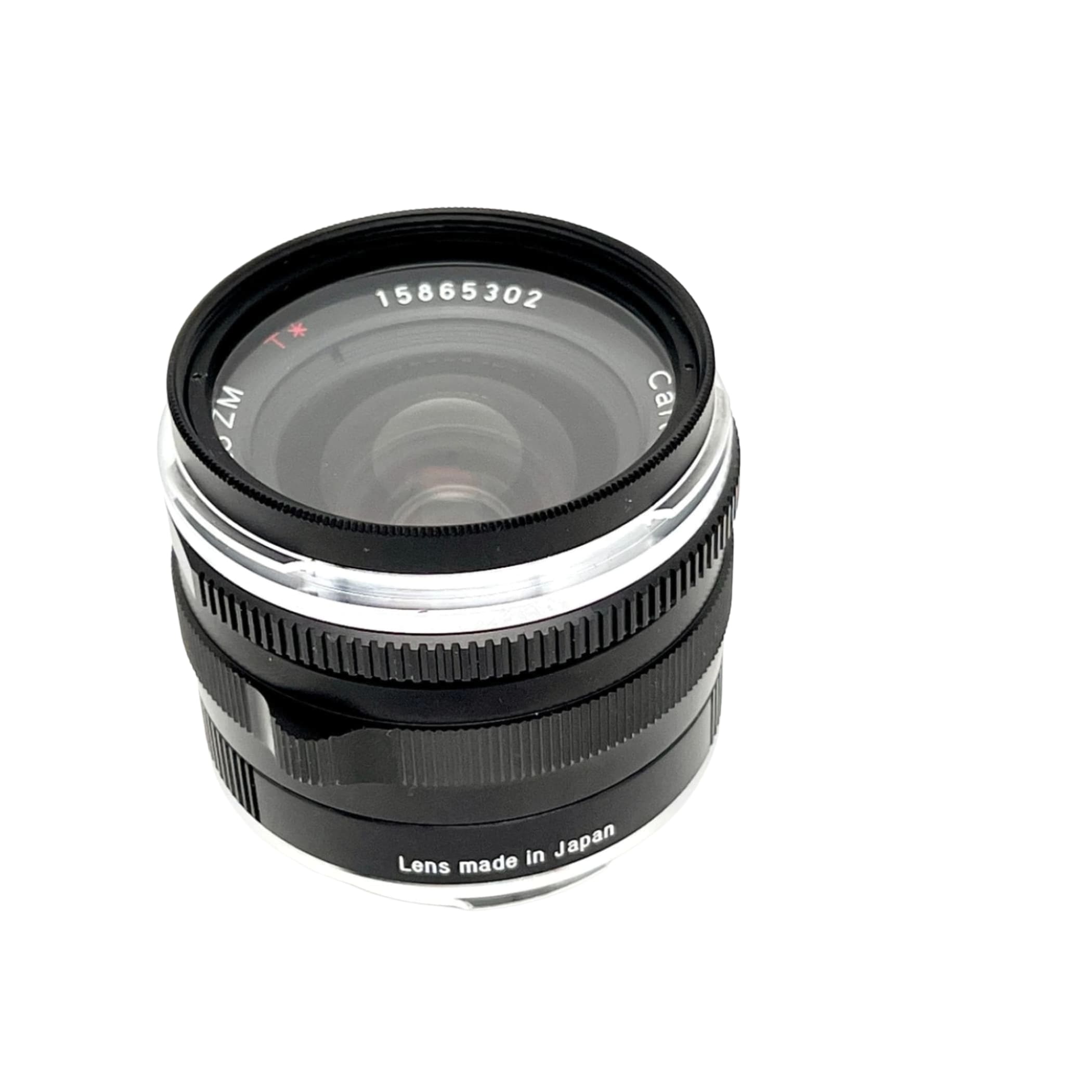 Black and silver canon zm lens with a textured focus ring, marked ’lens made in japan’ on its base.