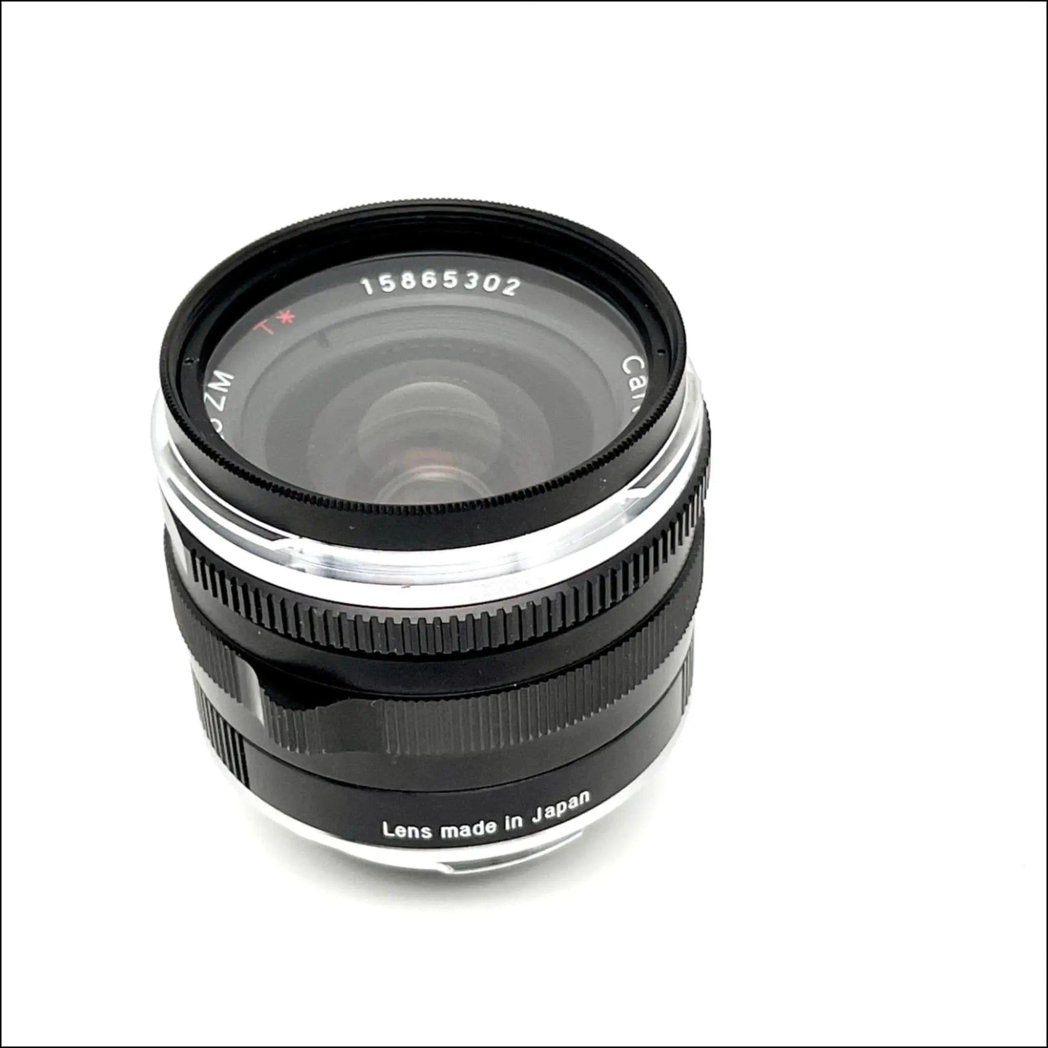 Black and silver canon zm lens with a textured focus ring, marked ’lens made in japan’ on its base.