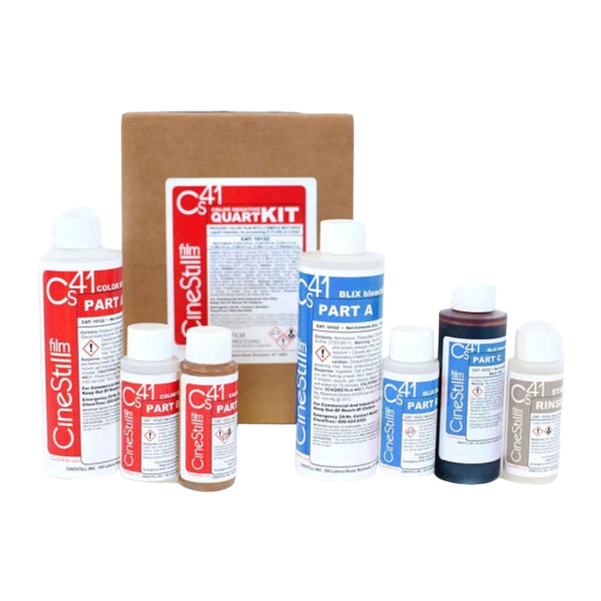 Cinestill c41 quattro kit containing various bottles of color developer, bleach fixer, and rinse solutions in white, blue, and brown containers with red or blue labels.