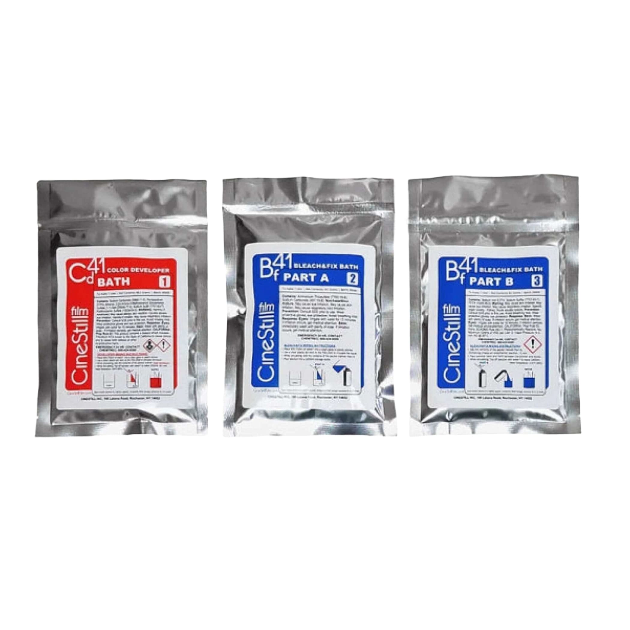 Three silver foil packets of cinestill film processing chemicals, labeled as color developer bath 1 and bleach/fix bath parts a and b.