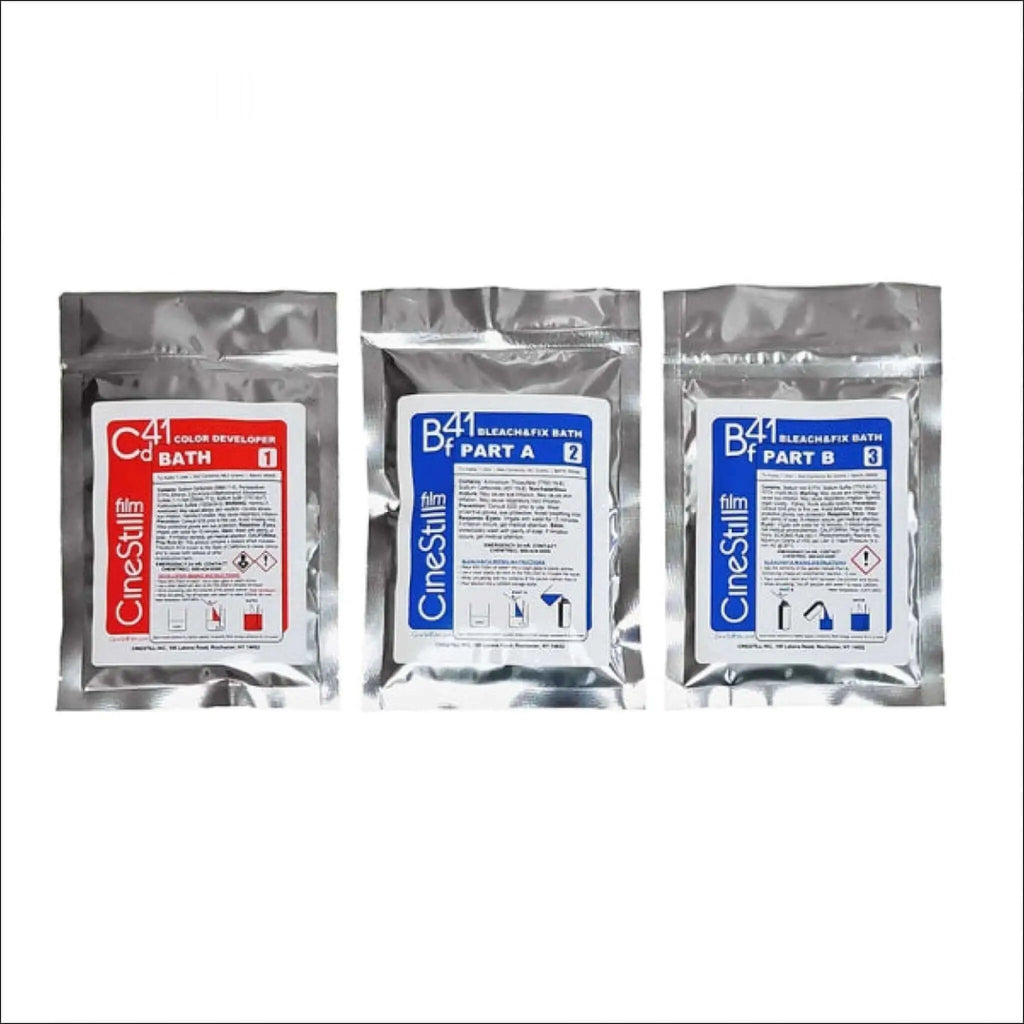 Three silver foil packets of cinestill film processing chemicals, labeled as color developer bath 1 and bleach/fix bath parts a and b.