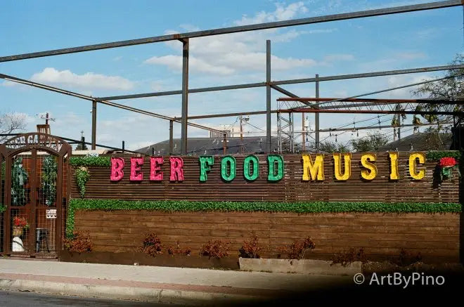 Colorful beer food music sign on Texas fence, view fullsize