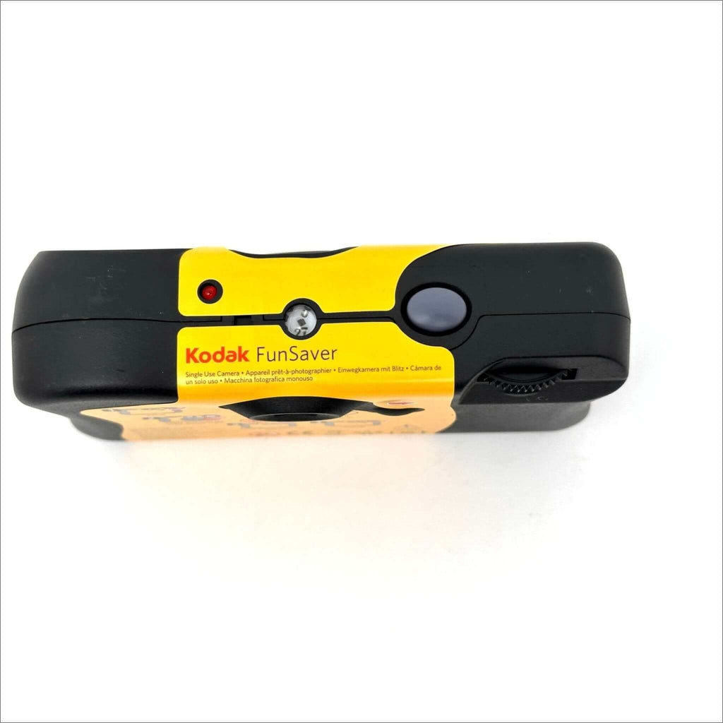 Kodak funsaver instant camera with black and yellow body, featuring a red shutter button and silver film advance lever.