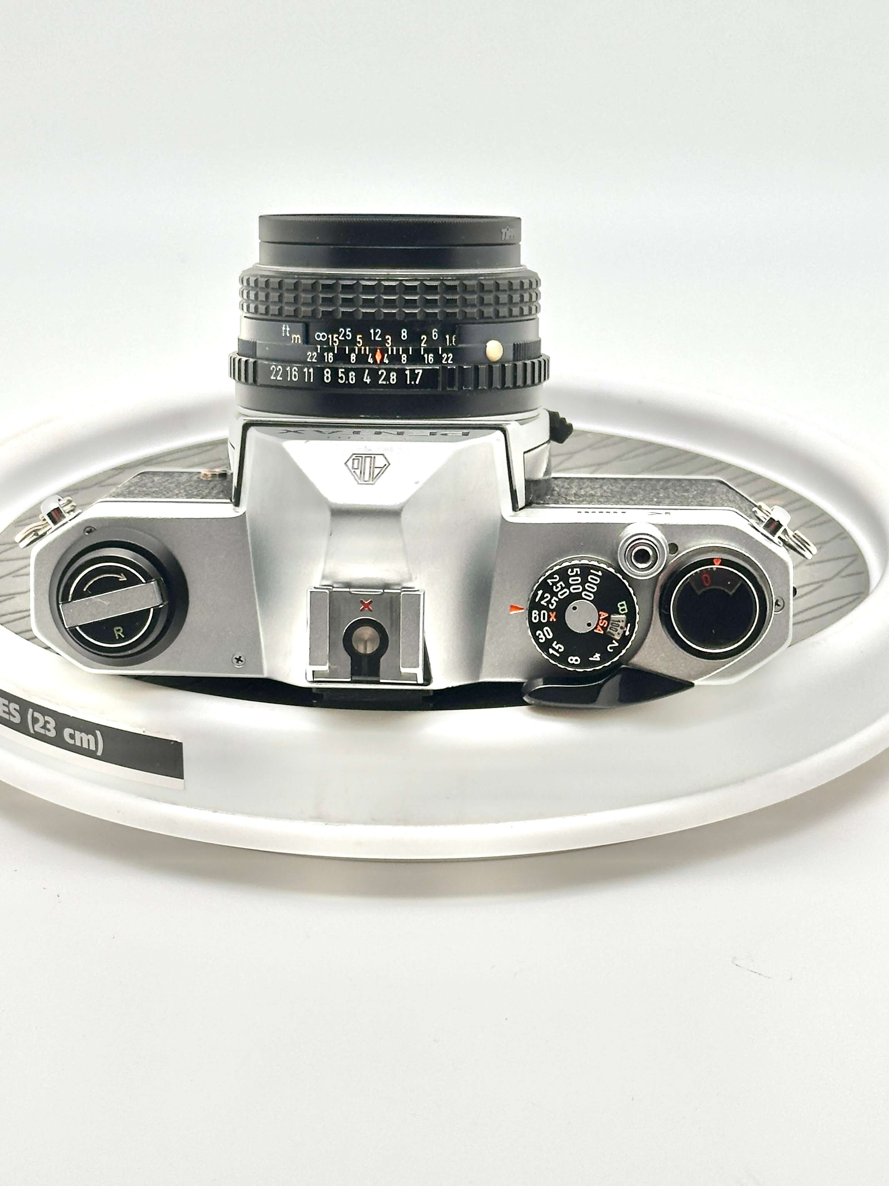 Silver-bodied canon ae-1 film camera with a black lens and textured grip.