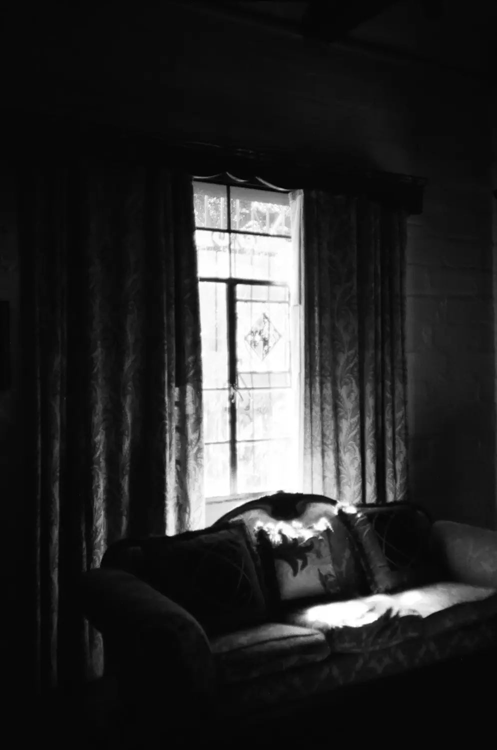 Dark patterned curtains frame stained glass window in Catlabs x Film shot